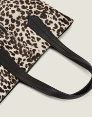 LEATHER HANDLE SHOT OF THE TAB TOTE IN SNOW LEOPARD
