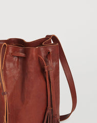 Detail of pull on Hammered Stud Bucket Bag in Cognac