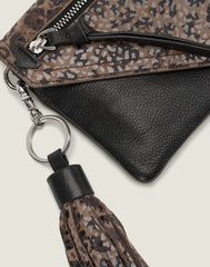 DETAIL SHOT OF THE TASSEL KEYCHAIN IN CHEETAH ON THE WEARABLE WALLET IN CHEETAH