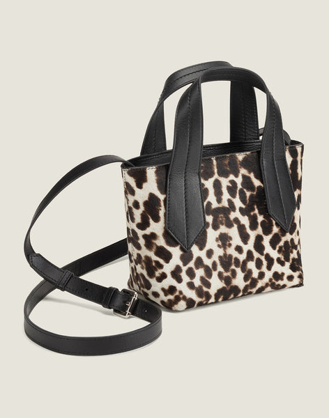SIDE SHOT OF THE TAB TOTE MINI IN SNOW LEOPARD AND LEATHER CROSSBODY STRAP